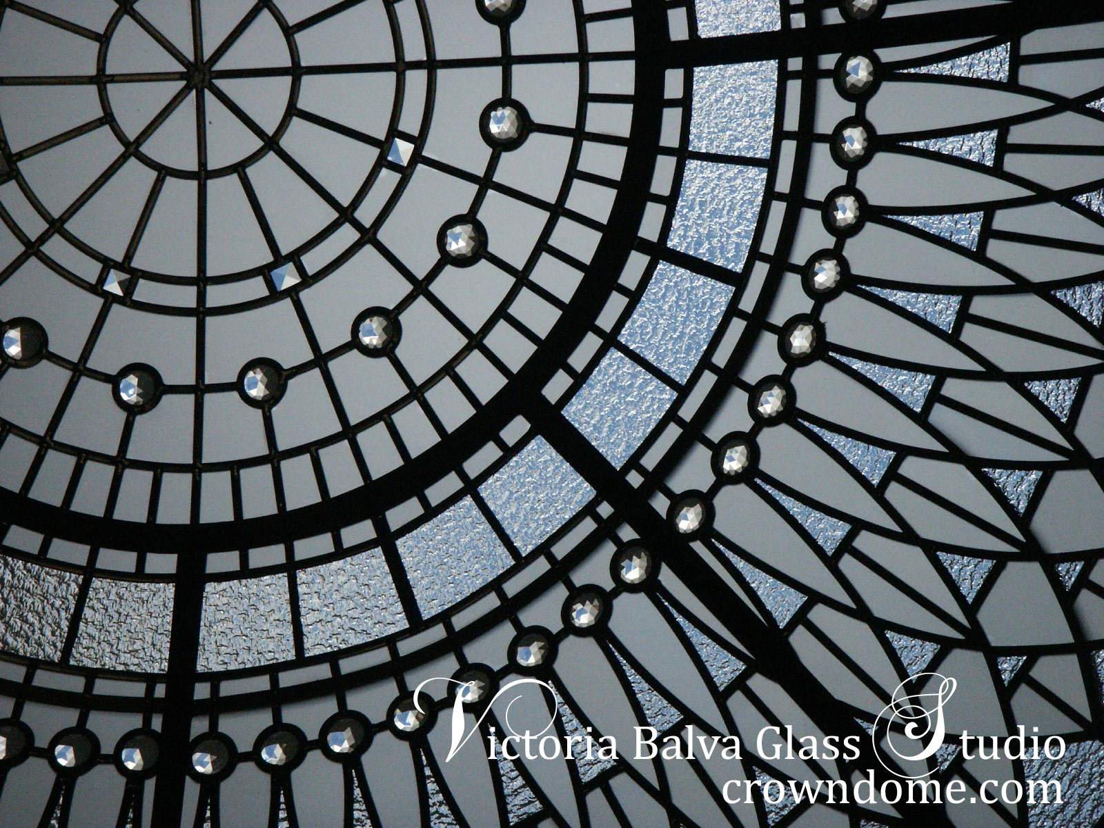 close up detail of stained and leaded glass dome with jewels and beveled glass