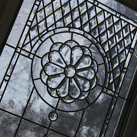Stained and leaded glass windows set with beveled glass and jewels for family room